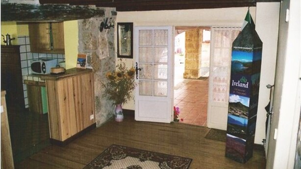 Un interior rústico con una puerta de madera, una pequeña cocina y un cartel de Irlanda.