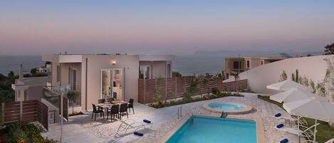 Una piscina al aire libre, sombrillas, sillones reclinables de piscina