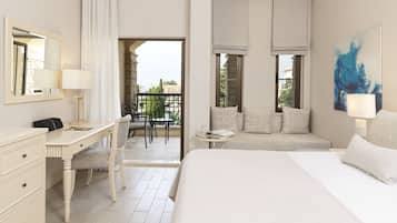 Een hotelkamer met een bed, een bureau, een stoel, een balkon en een schilderij.