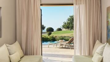 Una habitación con dos sofás frente a una piscina y vistas al campo de golf.