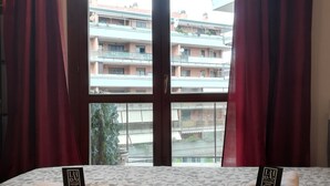 Ett hotellrum med en säng, två handdukar, en ros och en lapp på sängen.