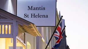 A building with a sign reading "Mantis St Helena" and multiple flags, including the UK flag. - Mantis St Helena (Jamestown)