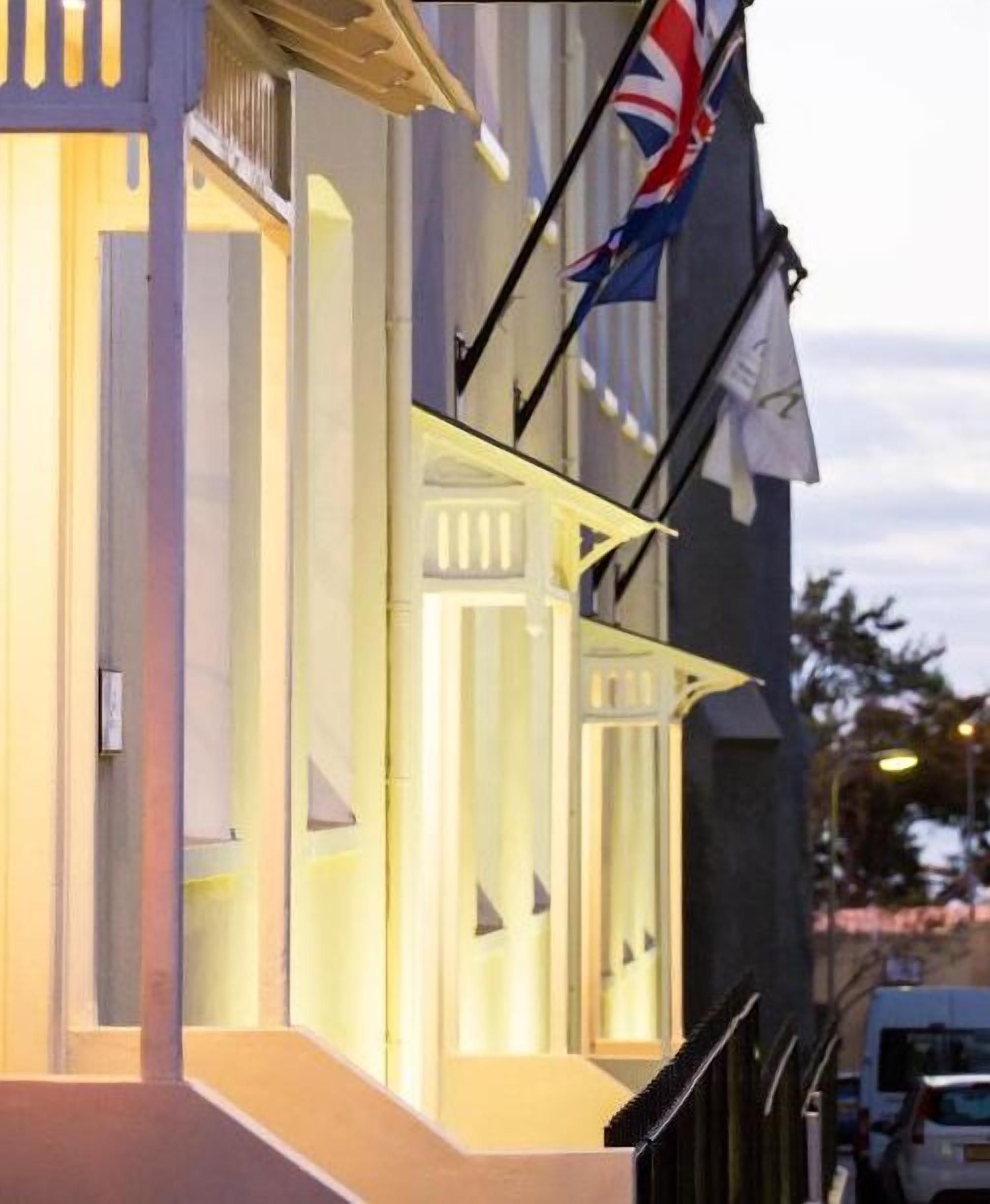 A building with a modern architectural style, featuring a prominent entrance with glass doors and a staircase leading up to it.