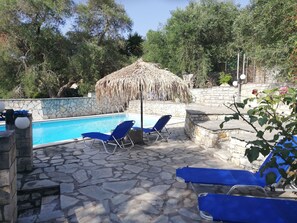 Una piscina al aire libre, tumbonas