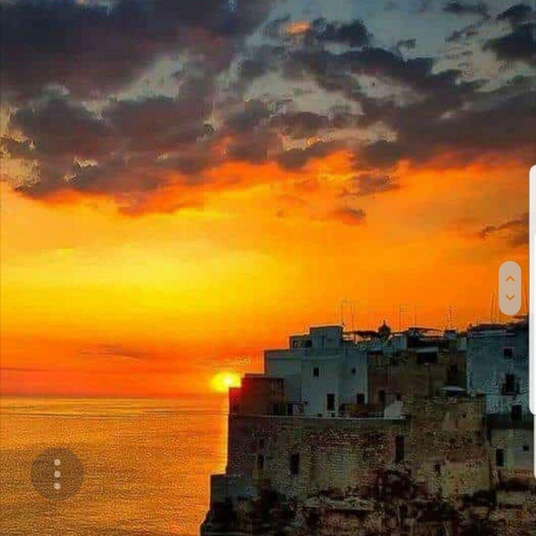 A sunset view over a coastal cityscape with buildings.