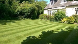 A well-maintained lawn with a house in the background. - Orchard Pond Bed & Breakfast (Cambridge)