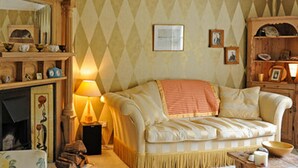 A cozy living room with a fireplace, a sofa, and a lamp. - Orchard Pond Bed & Breakfast (Cambridge)