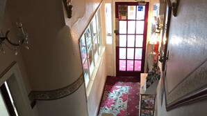 A staircase with a red carpet leading to a door with a window. - Montgomery Hotel (Blackpool)
