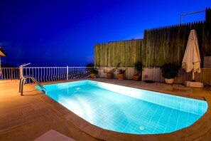 Alberca al aire libre y camastros 