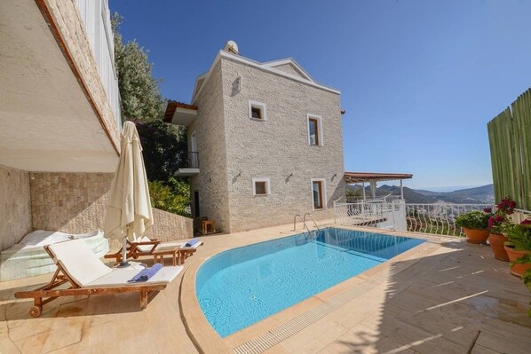 Alberca al aire libre y camastros 