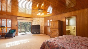 Une chambre spacieuse avec un grand lit, une télévision, une armoire en bois et une chaise.