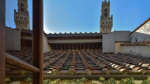 A view of a tiled roof with two towers in the background. - Cozy Studio w/ Terrace & Unparalleled Location (Firenze)