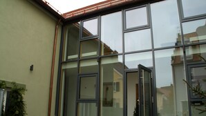 Un bâtiment moderne doté de grandes fenêtres en verre et d’une structure métallique.