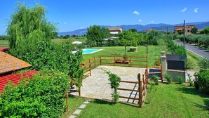 Ein Wohnhaus mit Swimmingpool, einem eingezäunten Garten und Blick auf Berge.