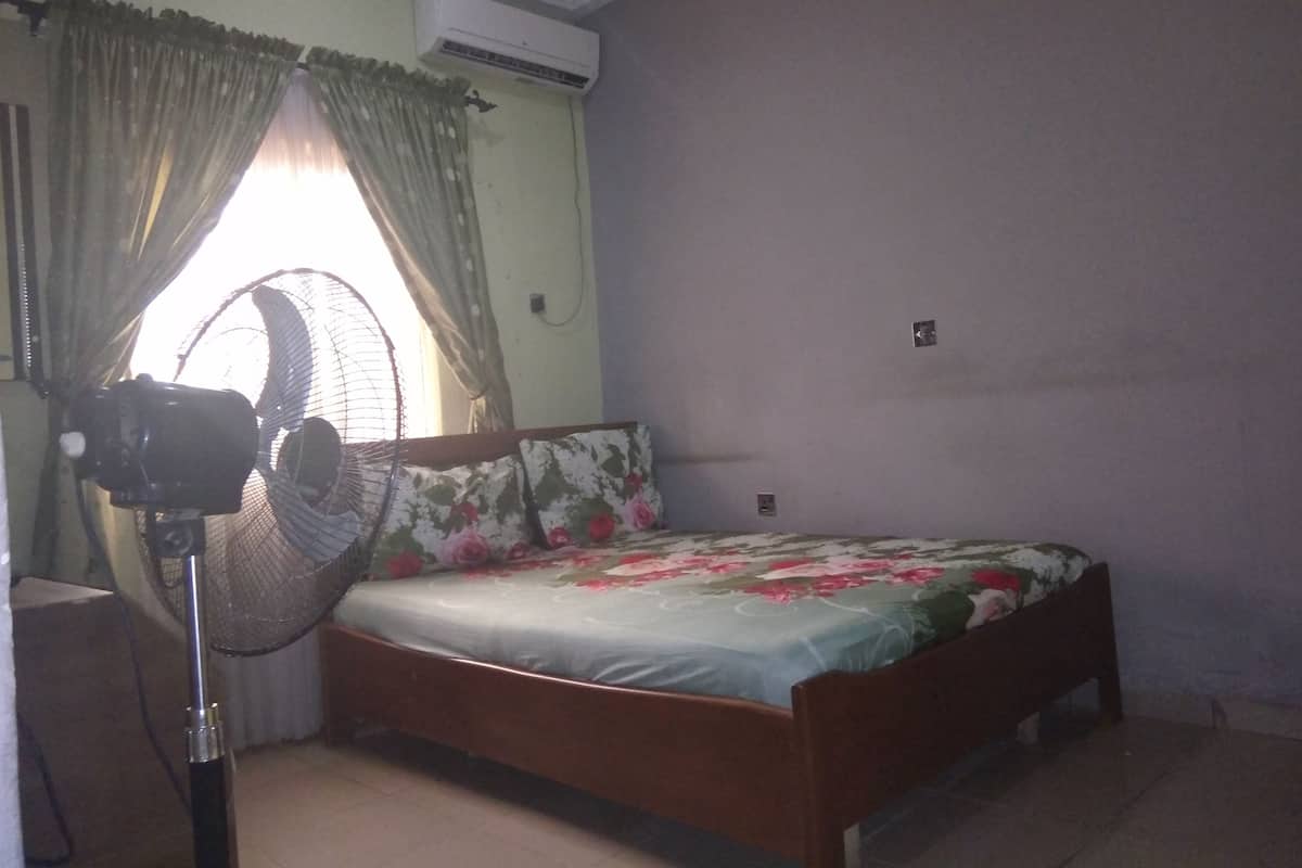 Un dormitorio con cama, ventilador y aire acondicionado.