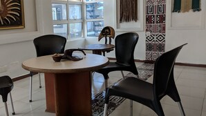 A dining area with a round table, four black chairs, and a decorative piece on the table. - NatureMark Gallery and Guest House (Uyo)