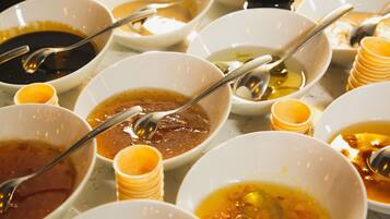 A variety of bowls with different sauces and condiments, some with stacked small bowls beside them.