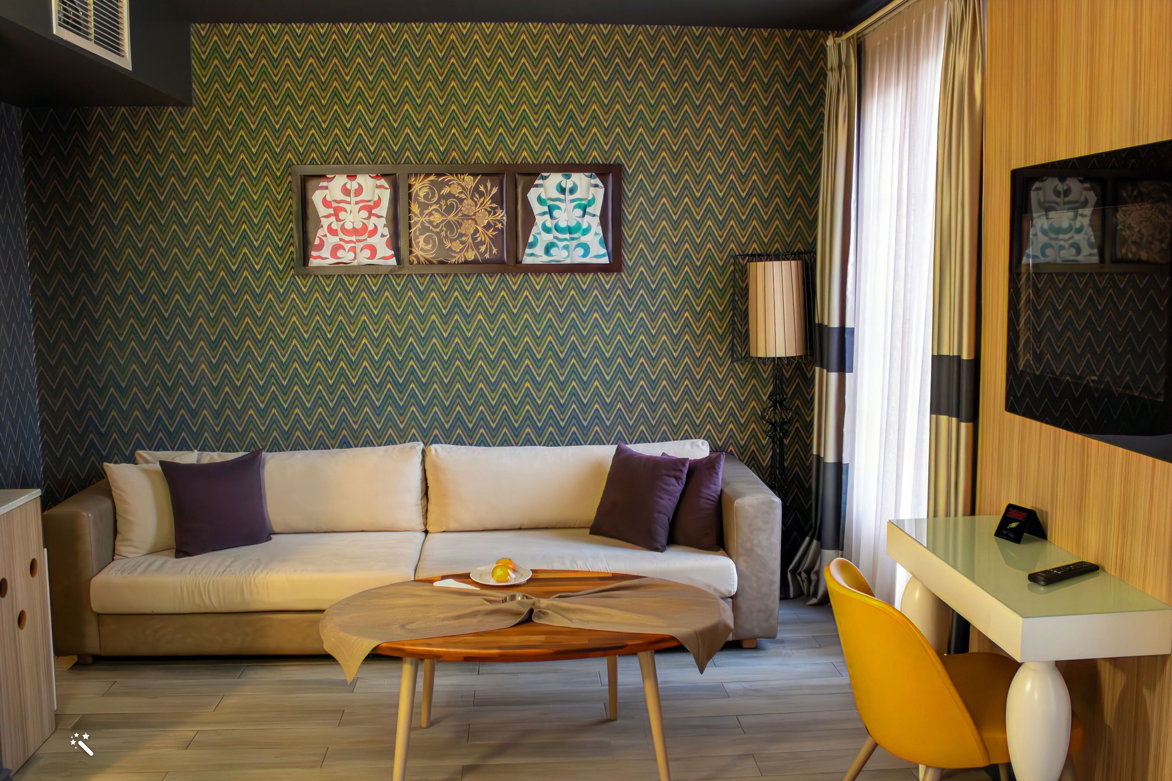 A modern living room with a sofa, a coffee table, a dining table, and a lamp.