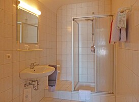 Un baño con lavamanos, espejo y ducha.