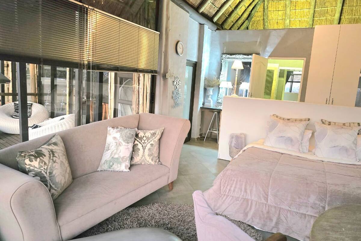 A modern bedroom with a sofa, a bed, and a desk.