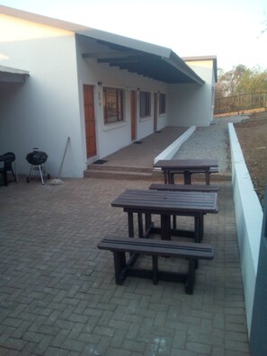 Enjoy outdoor dining and cooking facilities on the patio, featuring picnic tables and a barbecue grill.