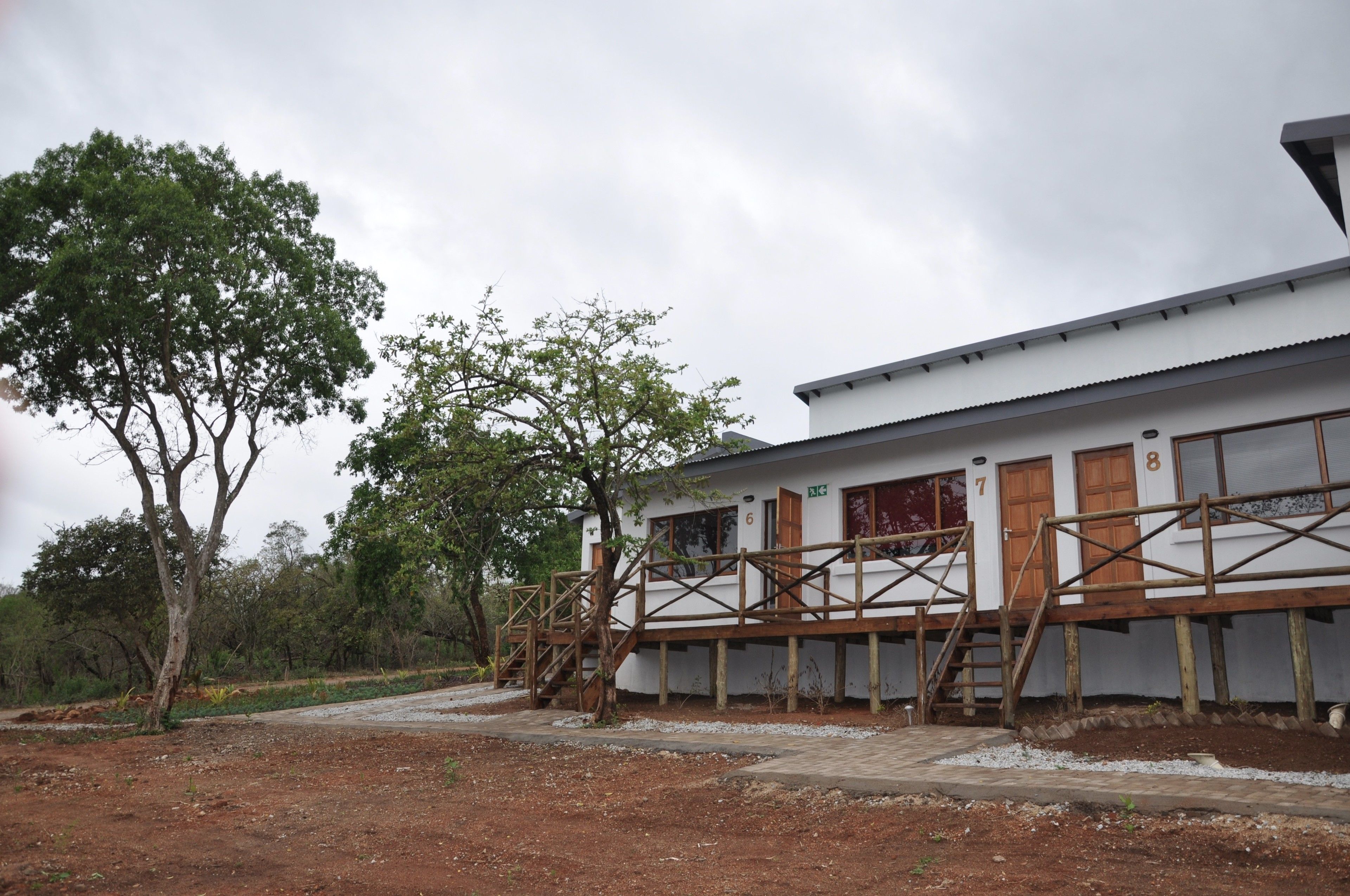 A two-story building with a white exterior and wooden deck.