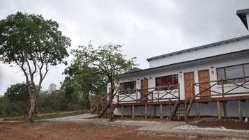 A two-story building with a white exterior and wooden deck.