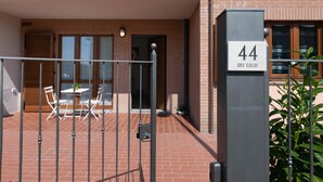 Una entrada cerrada a un edificio con una placa con el número '44' y un cartel que dice 'DEI GELSI'.