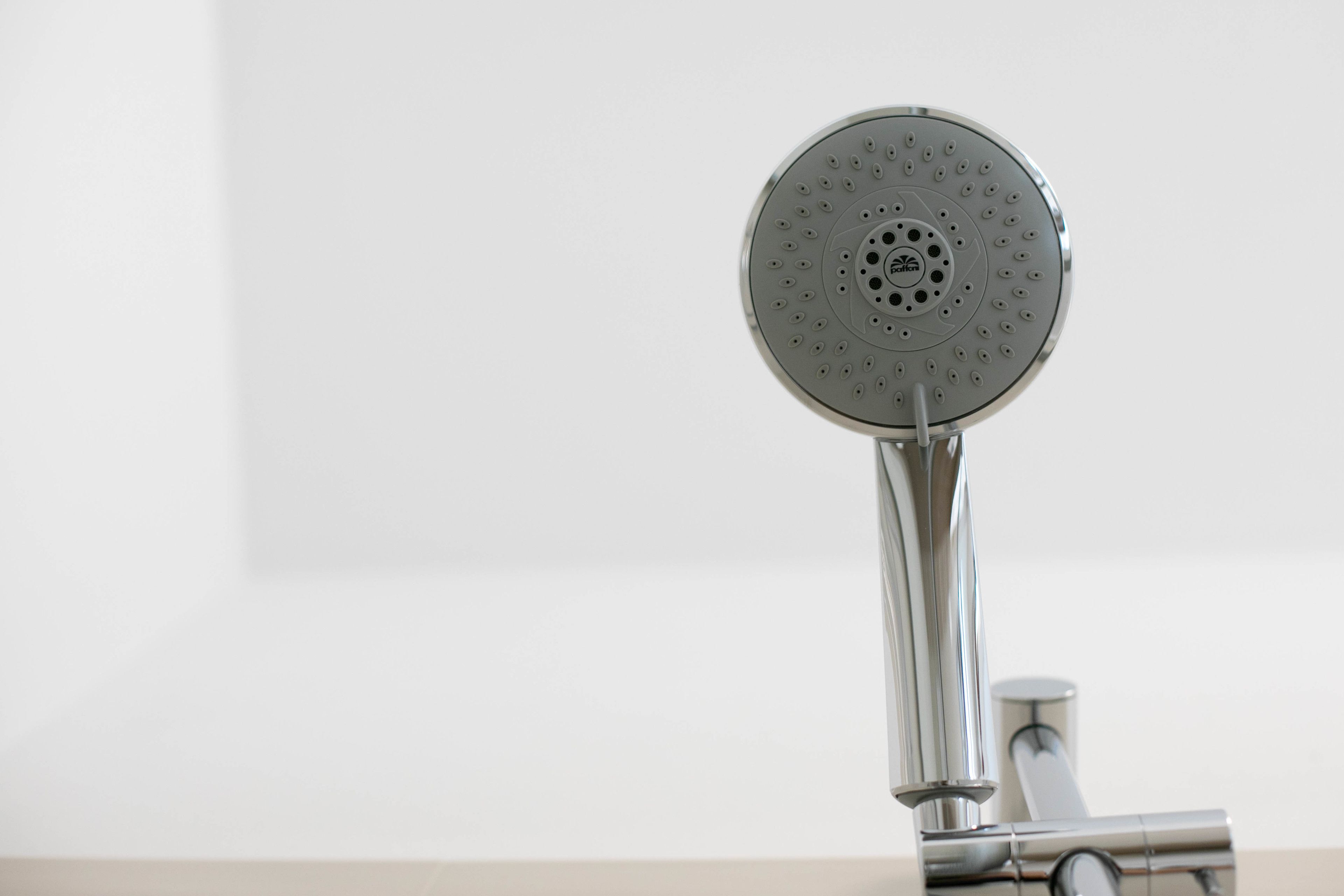 A modern showerhead with a circular design and multiple water outlets.