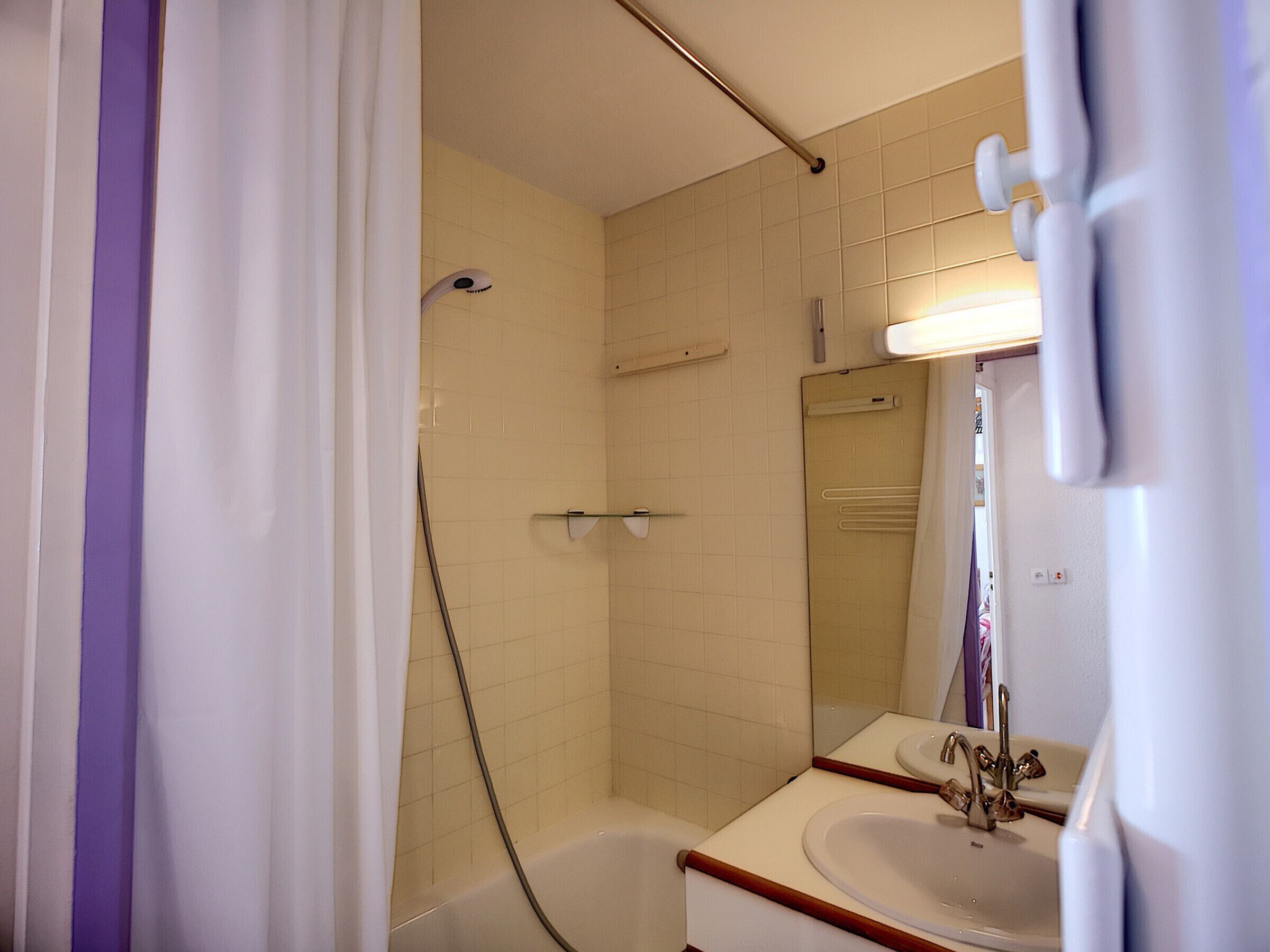 Un baño con bañera, lavamanos y ducha.