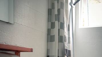 A bathroom with a white sink, a toilet, and a shower with a checkered curtain.