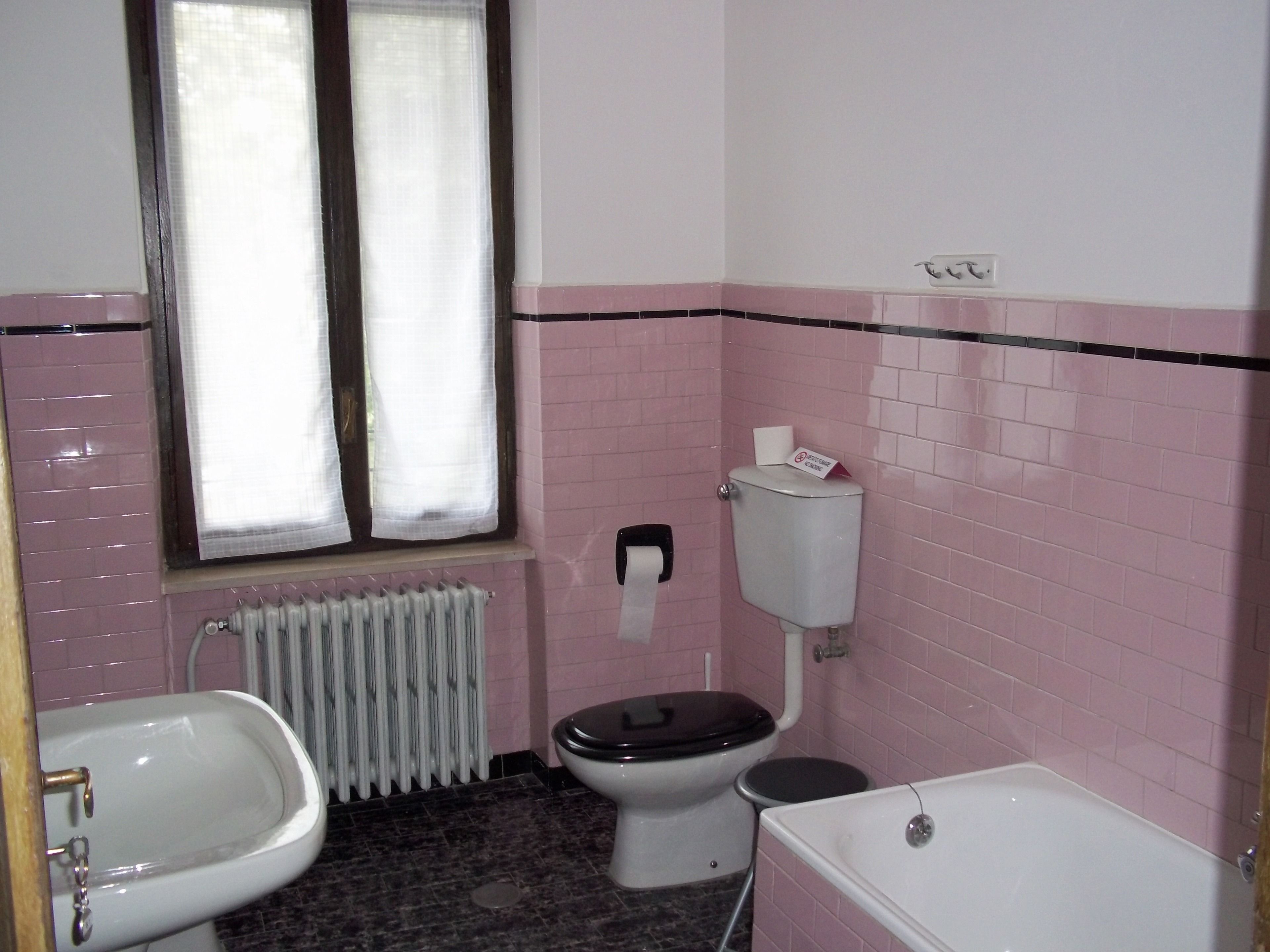 Une salle de bain équipée de toilettes, d’un bidet et d’une baignoire.