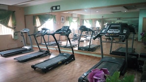 A gym with treadmills, exercise bikes, and weights. - Mataan Hotel  Suites (Ibadan)