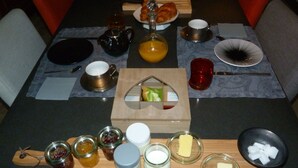 A breakfast setting with various food items and condiments on a table. - Chambres d'hôtes Au BO Voyage (Tavant)