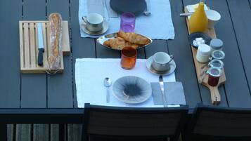Una mesa de desayuno con croissants, pan y diferentes salsas.
