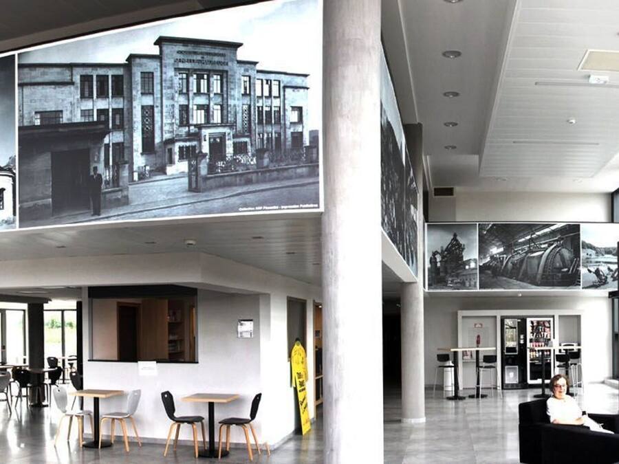 A modern interior with a dining area, a bar, and a seating area with a view of the cityscape through large windows.