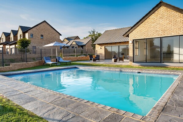 Outdoor pool, pool loungers - Kyalami Creek Luxury Apartments (Midrand)