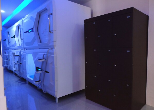 A row of white lockers with a black security box beside them.