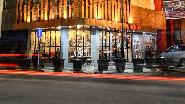 Un edificio moderno con fachada de vidrio y un letrero que dice 'Coffee with a Smile'.