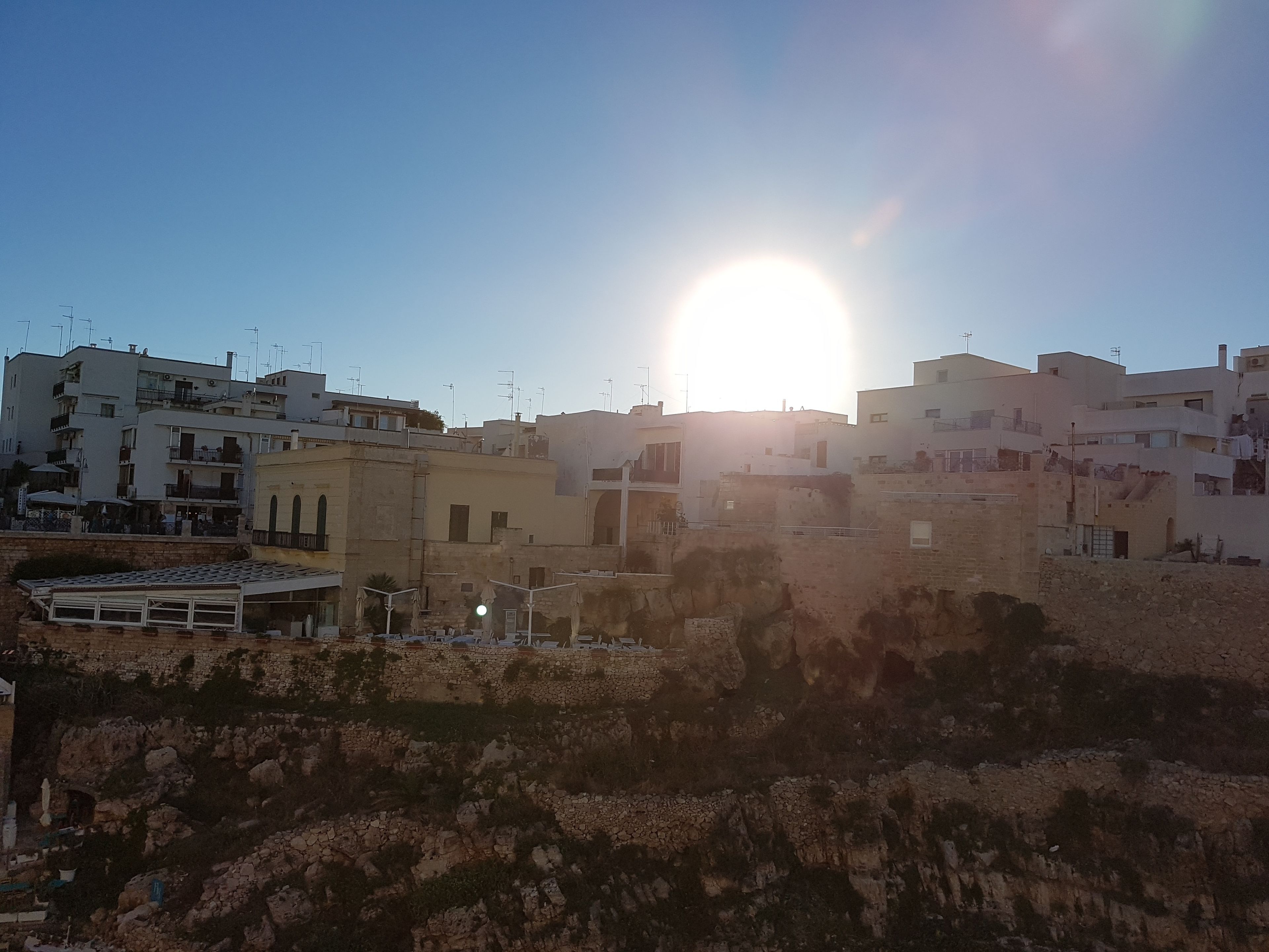 A coastal town with buildings and rocky terrain.