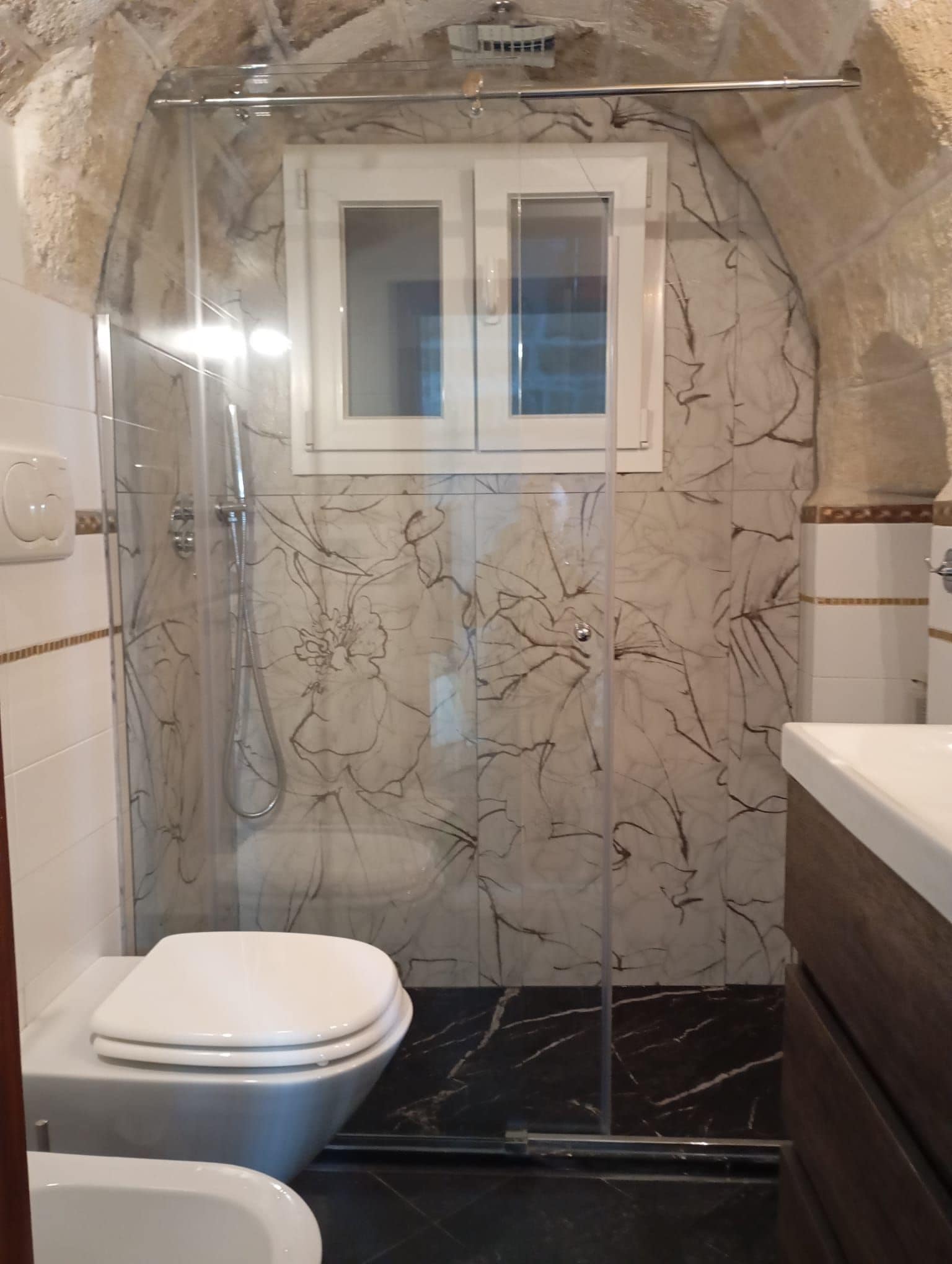 Un bagno con cabina doccia, un water e un lavandino.