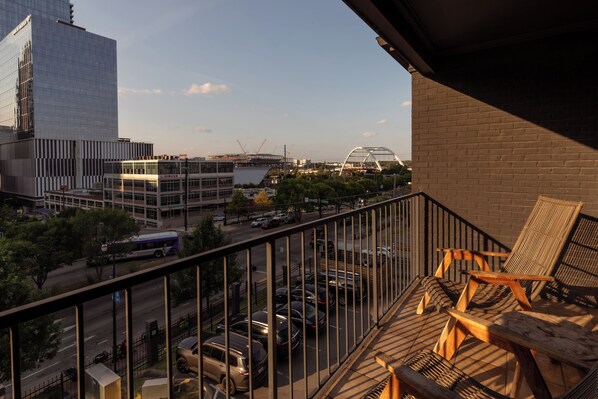 Un balcón con vistas a un paisaje urbano, que incluye edificios modernos y un puente.