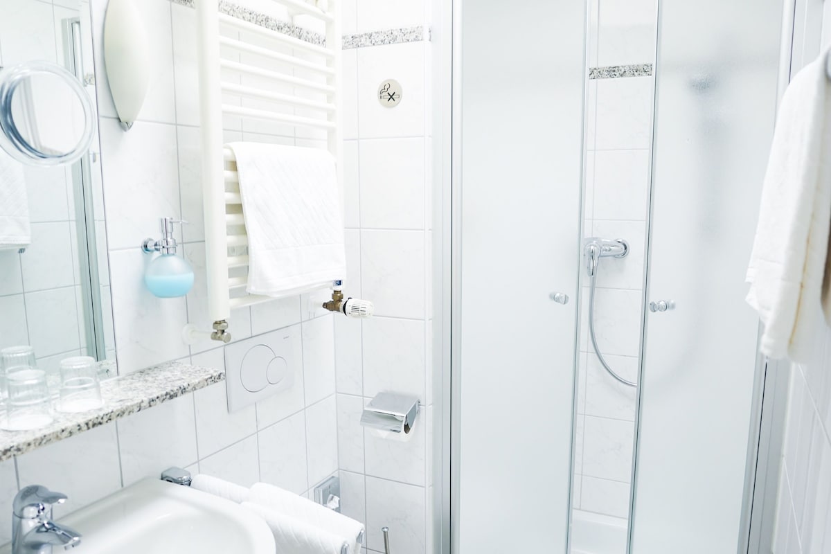 A modern bathroom with a sink, toilet, and glass-enclosed shower.
