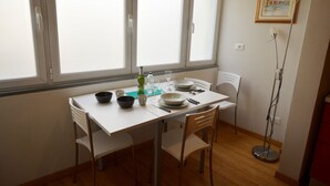Een eetgedeelte met een tafel voor vier personen, compleet met kommen, borden en bestek.