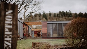 A modern building with a wooden deck and a covered outdoor seating area. - mein kleinHOTEL Biedenkopf (Biedenkopf)