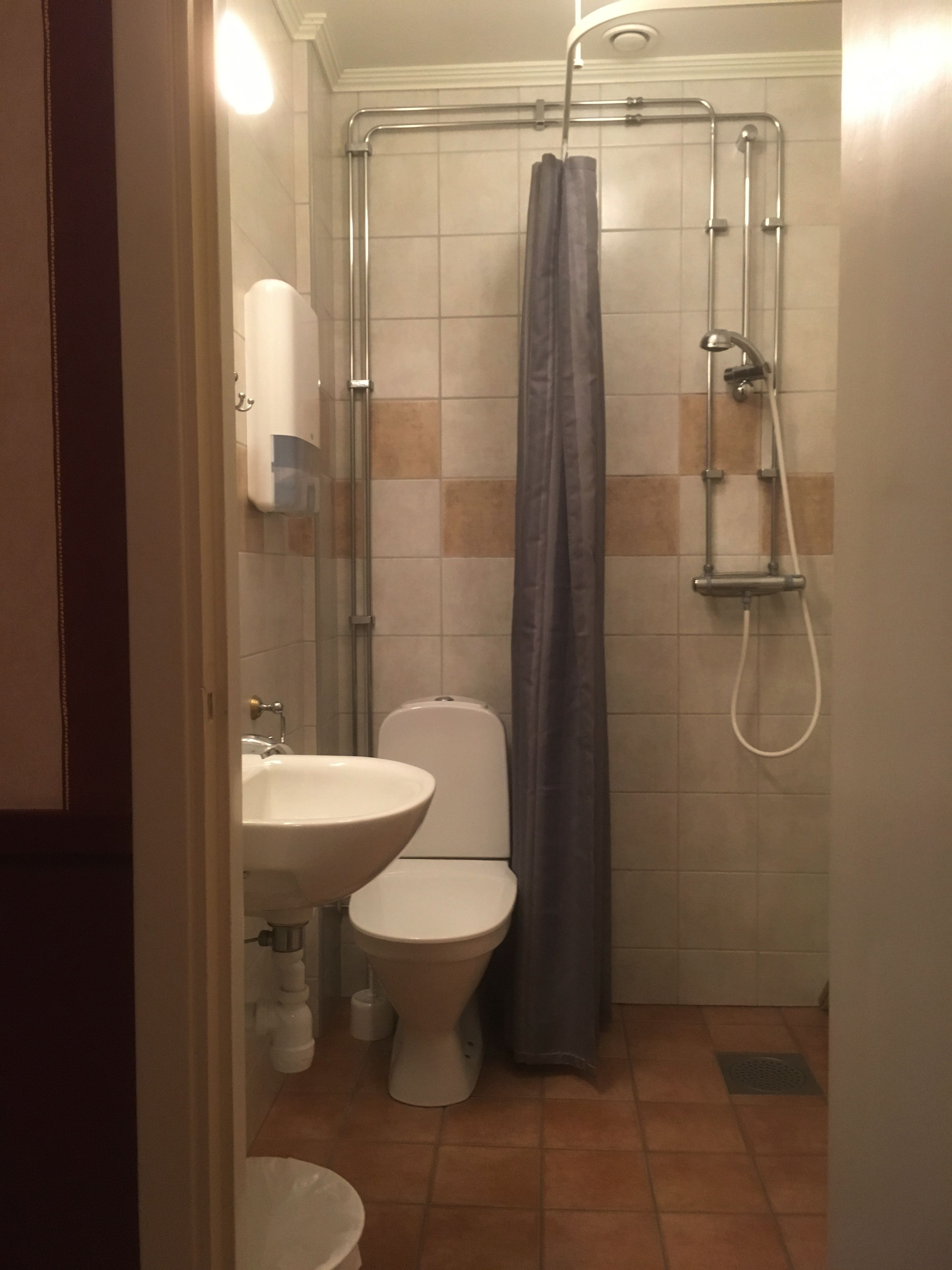 A bathroom with a shower, toilet, and sink.