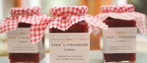 Three jars of jam with red and white checkered cloths and labels.