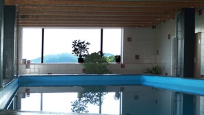 A swimming pool with a view of mountains through large windows. - DAHL Hotel & Restaurant GmbH (Wachtberg)