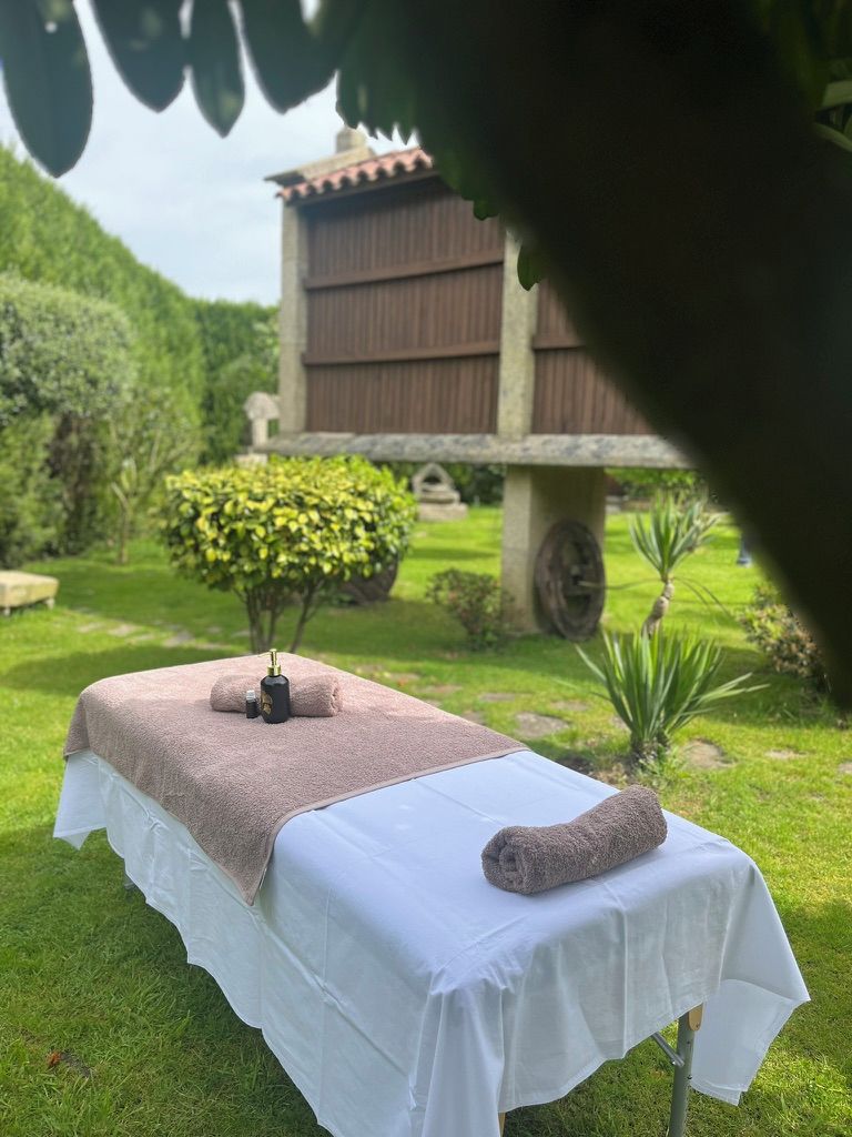 Ein Massagetisch im Freien mit Handtuch und Ölflasche.