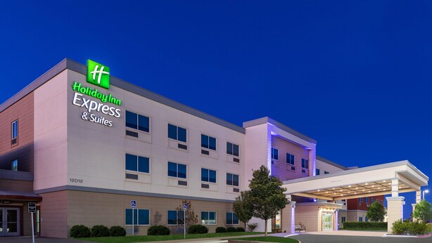 Edifício Holiday Inn Express & Suites com fachada moderna, diversas janelas e área de entrada coberta.
